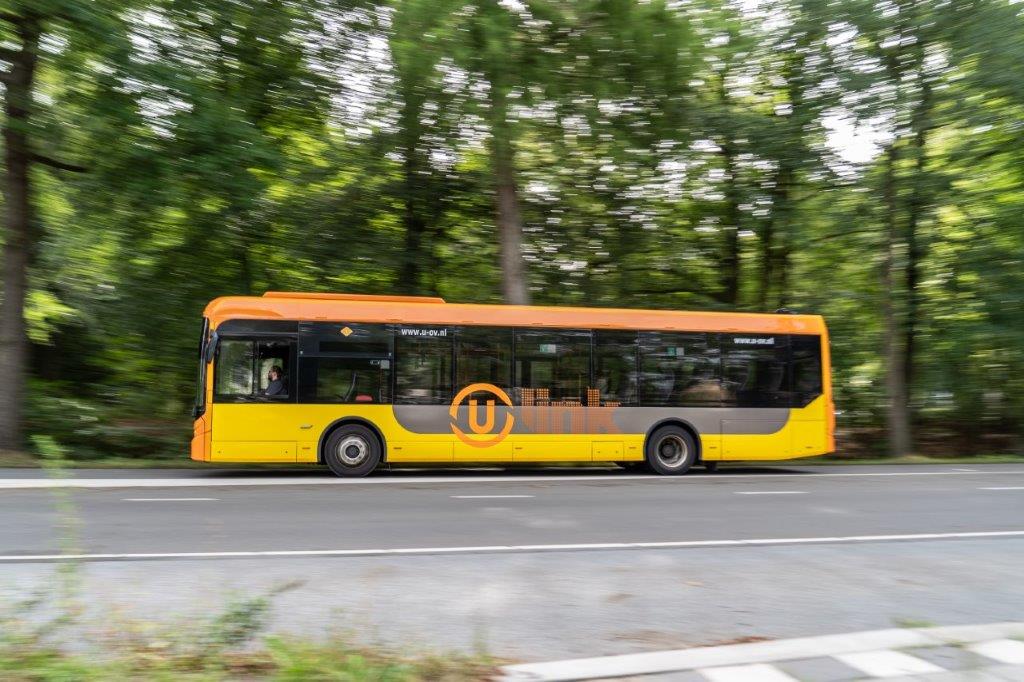 Ulink bus traveling through a wooded area.