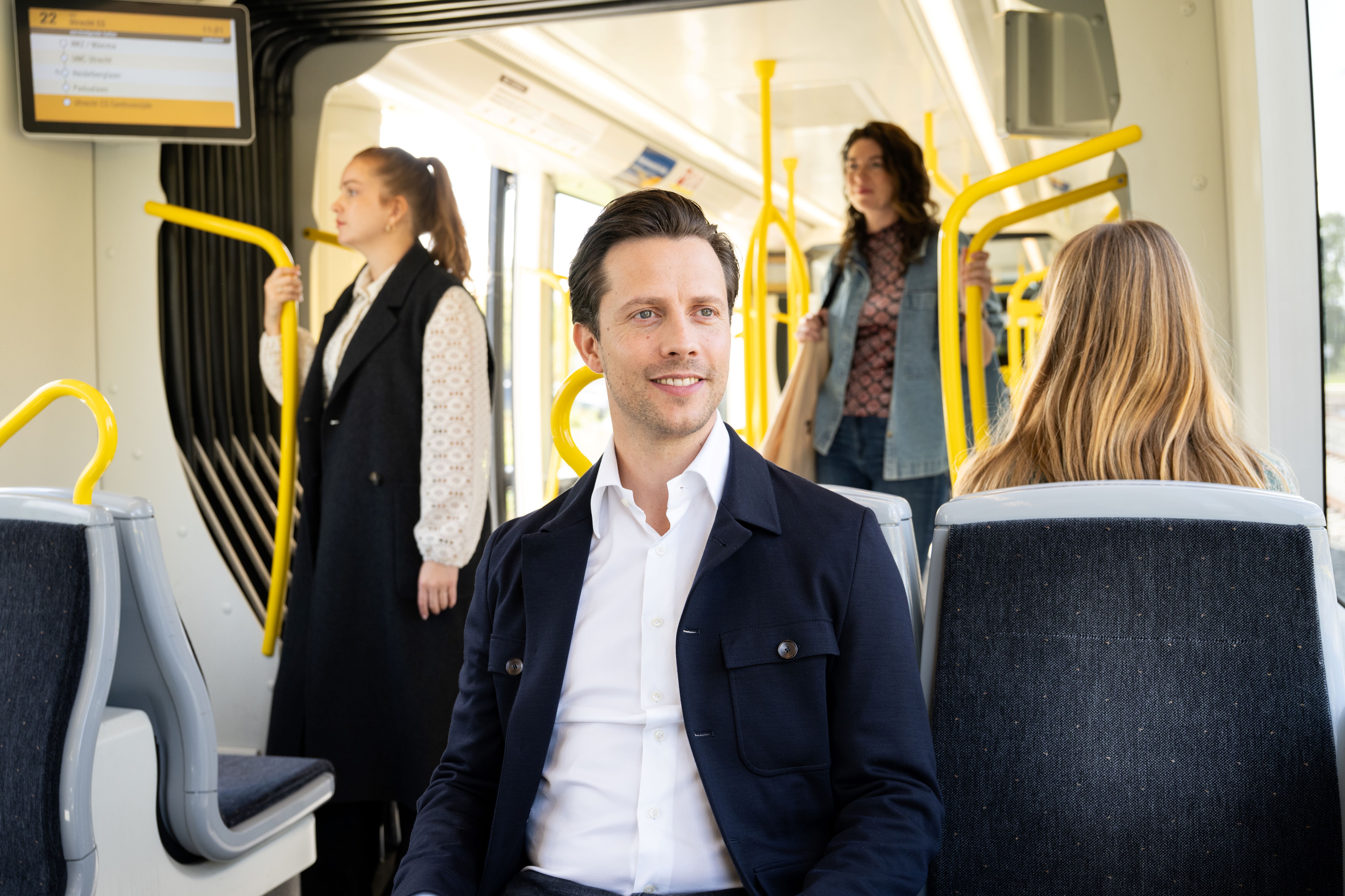 Passenger on tram, sitting on a two-seater.