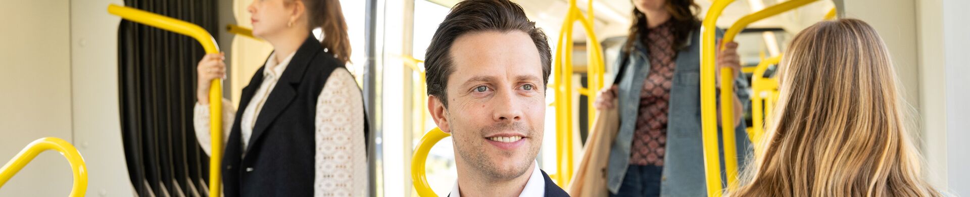 Passenger on tram, sitting on a two-seater.