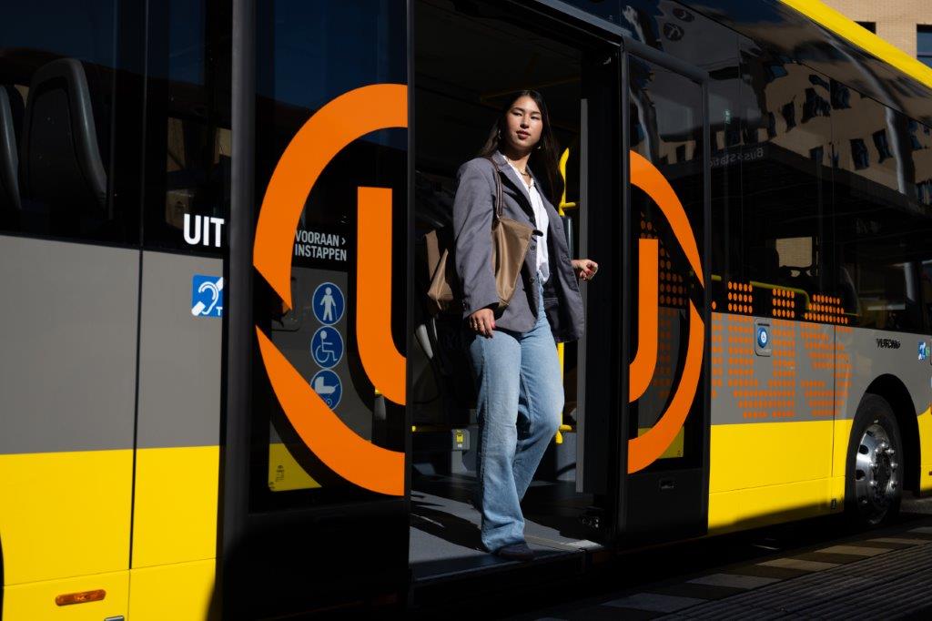 Reiziger stapt uit de U-OV bus bij de achterdeur