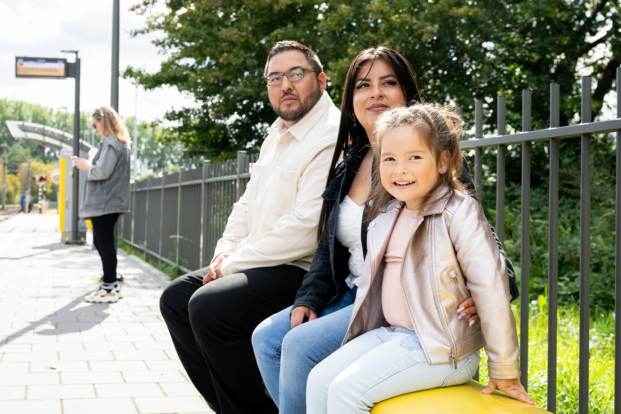 gezin aan het wachten op een bankje op de tramhalte