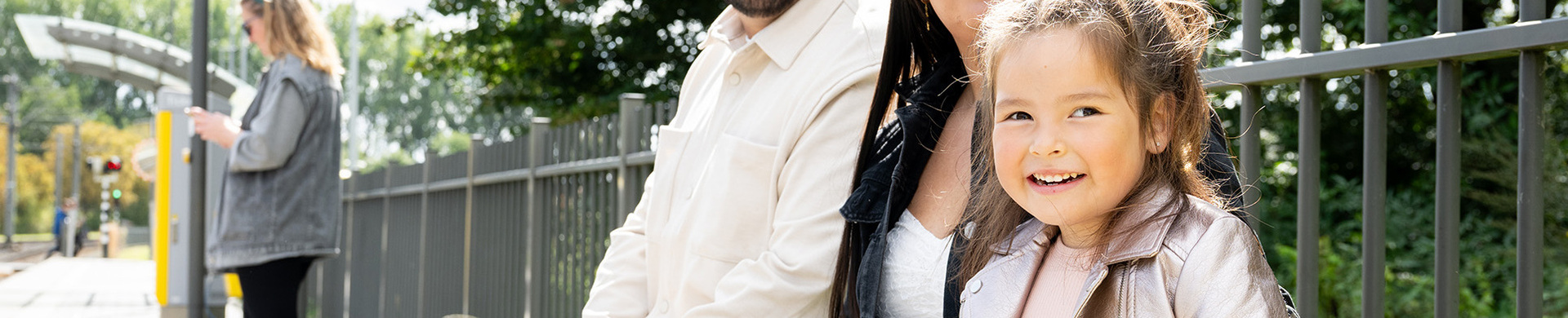 gezin aan het wachten op een bankje op de tramhalte