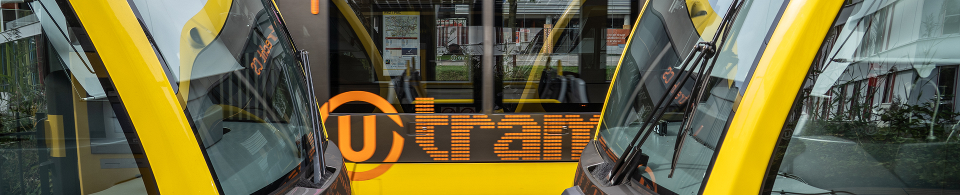 Yellow U-OV tram bound for Utrecht Central Station, photographed between two coupled trams at a tram depot in Utrecht.