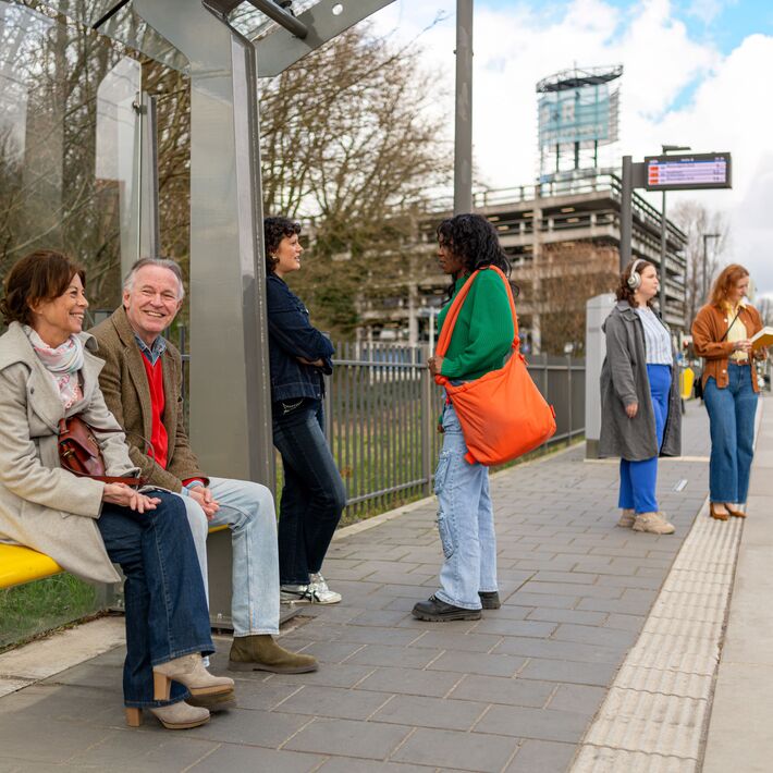 Wachtende mensen bij een tramhalte.