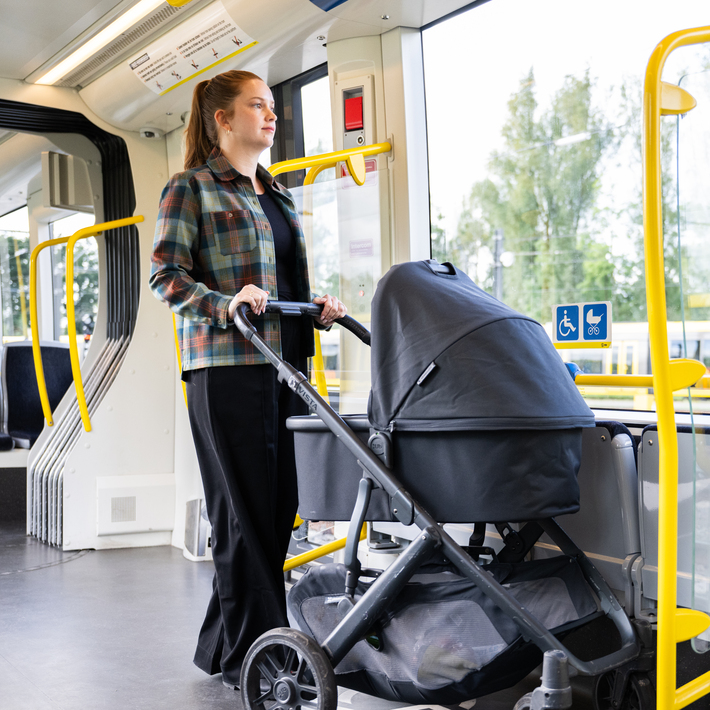 Vrouw met kinderwagen in bus