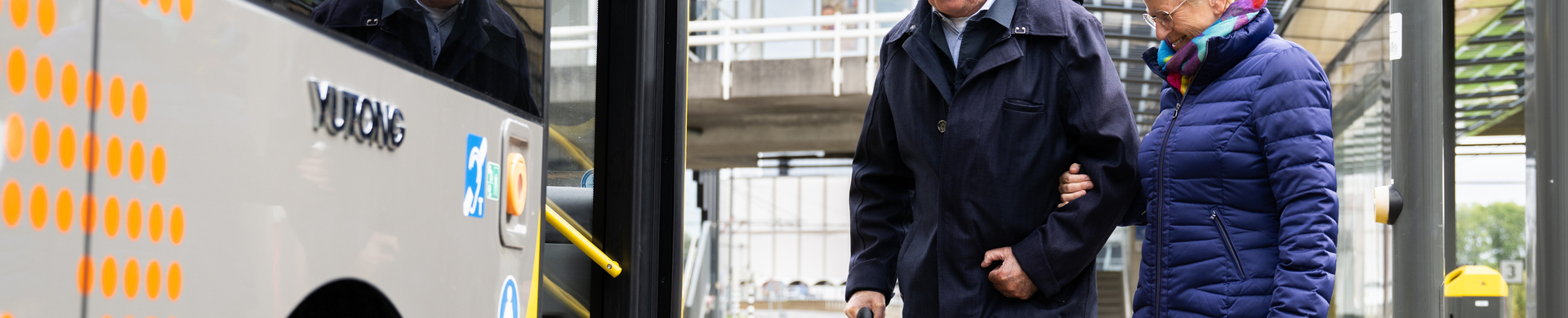 Oudere reizigers stappen in in een bus.